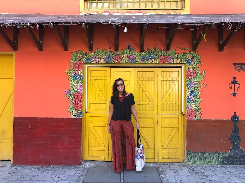 Inês frente a una colorida pared de El Poblado