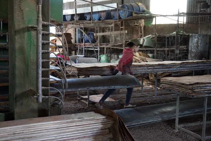 Una de las trabajadoras de la fábrica, cargando una chapa muy pesada de metal. 